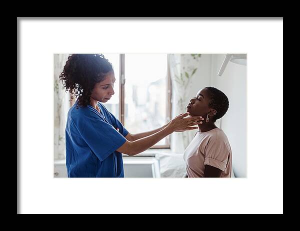 Mid Adult Framed Print featuring the photograph Female nurse examining throat of young patient in hospital by Maskot