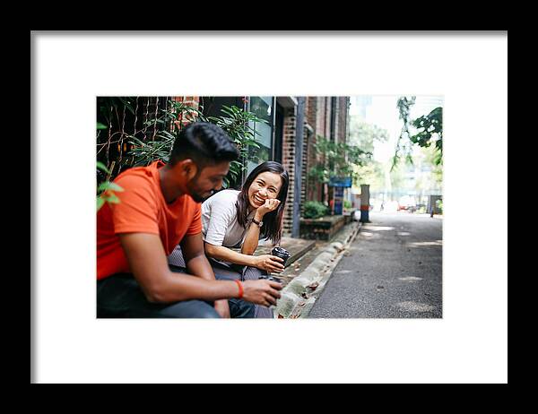 Asian And Indian Ethnicities Framed Print featuring the photograph Friends chatting outdoors in Kuala Lumpur, Malaysia by Lechatnoir