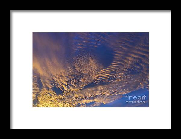 Clouds Framed Print featuring the photograph Golden and dark blue cloudscape at sunset by Adriana Mueller
