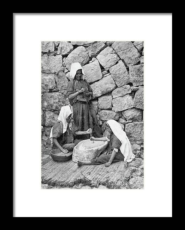 Women Framed Print featuring the photograph Grinding in Bethlehem in 1917 by Munir Alawi