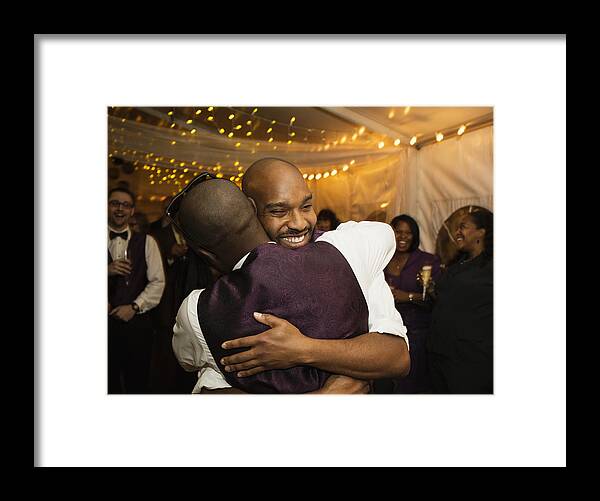 Celebration Framed Print featuring the photograph Groom hugging groomsman at reception by Roberto Westbrook