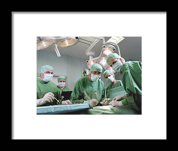 Expertise Framed Print featuring the photograph Group of surgeons in operating theatre, portrait by Jochen Sands