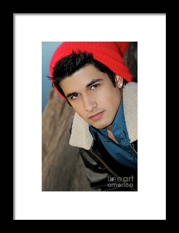 Face Framed Print featuring the photograph Handsome young hispanic man portrait wearing a red ski cap by Gunther Allen