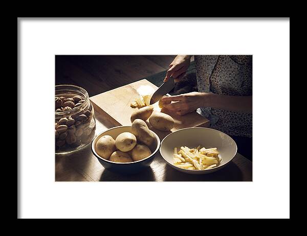Shadow Framed Print featuring the photograph High angle view of woman cutting potatoes on cutting board at home by Cavan Images