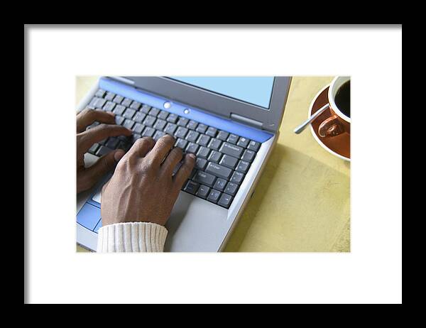Shadow Framed Print featuring the photograph High angle view of young man operating a laptop by Colorblind Images LLC