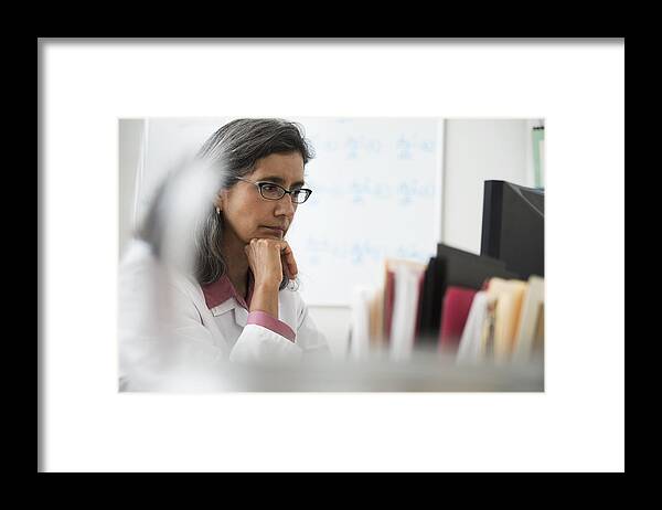 Working Framed Print featuring the photograph Hispanic doctor using computer at desk by Jose Luis Pelaez Inc