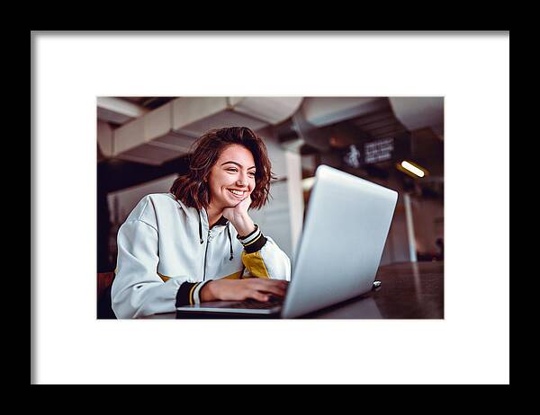 Working Framed Print featuring the photograph Hispanic Female Studying On Laptop by AleksandarGeorgiev