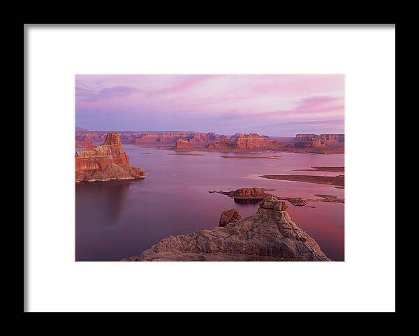 Scenics Framed Print featuring the photograph Lake Powell Near Page Arizona With Red Rock Formations In The Pink Haze Of Morning by Rubberball