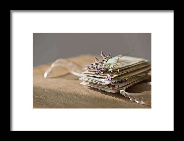 Large Group Of Objects Framed Print featuring the photograph Lavender stem on stack of letters by Tetra Images