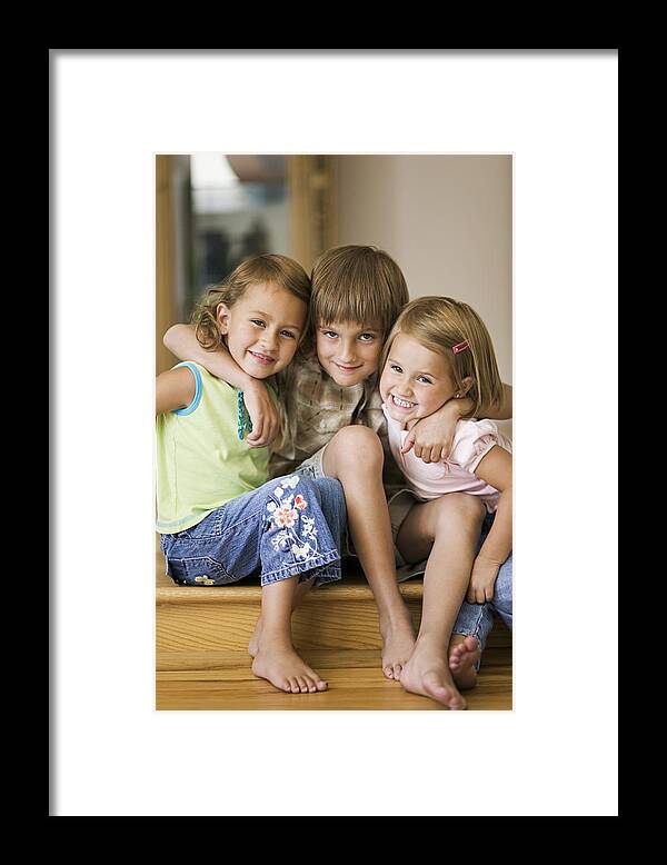 People Framed Print featuring the photograph Lifestyle Portrait Of Three Siblings As They Put Their Arms Around Each Other And Smile by Digital Vision
