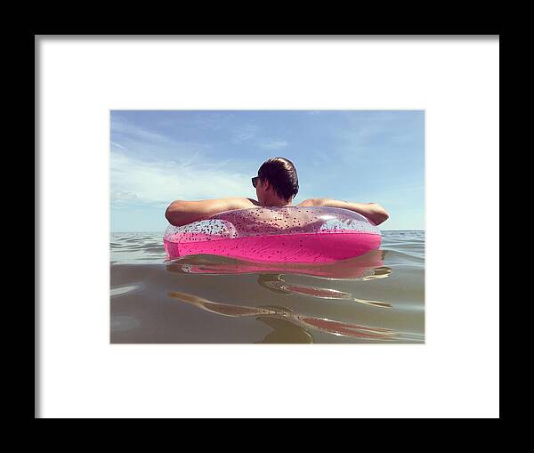 Scenics Framed Print featuring the photograph Man Floating in a Pink Inner Tube in the Ocean by Cyndi Monaghan