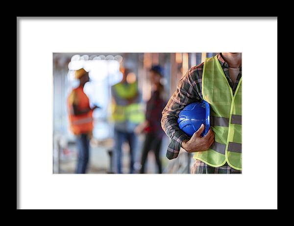 Expertise Framed Print featuring the photograph Man holding blue helmet close up by Ljubaphoto