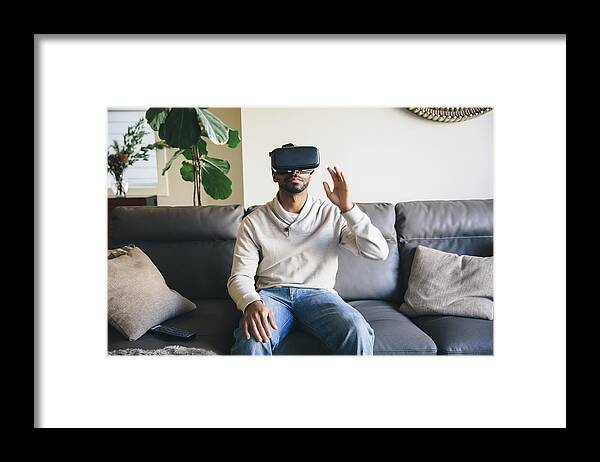Tranquility Framed Print featuring the photograph Mixed race man using virtual reality goggles by Inti St Clair