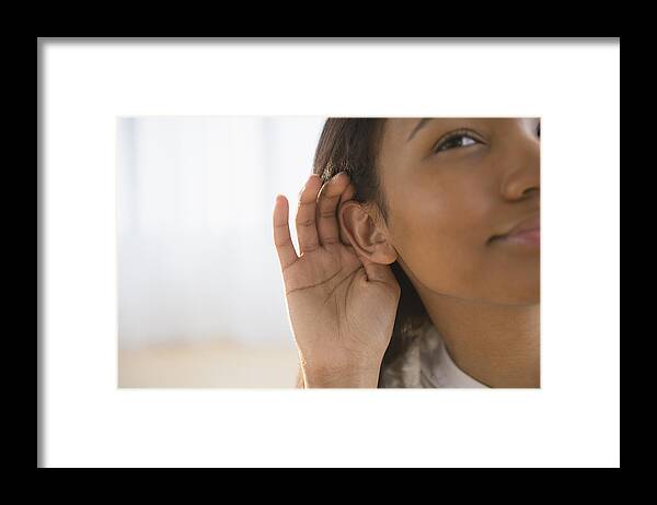 Asian And Indian Ethnicities Framed Print featuring the photograph Mixed race woman cupping her ear by JGI/Jamie Grill