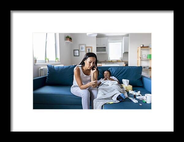 Cold And Flu Framed Print featuring the photograph Mother Calling Doctor on the Phone because Her Sick Little Boy by PixelsEffect