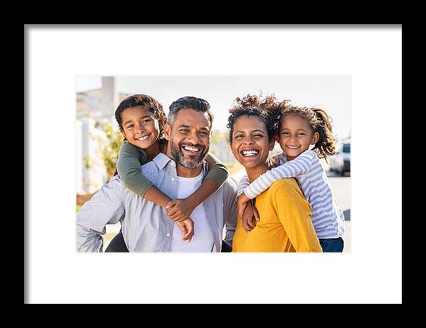 Asian And Indian Ethnicities Framed Print featuring the photograph Multiethnic parents giving children piggyback ride by Ridofranz