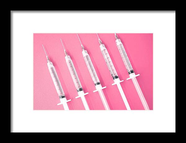 Medical Injection Framed Print featuring the photograph Multiple Syringes With Needles on Pink Background by Grace Cary