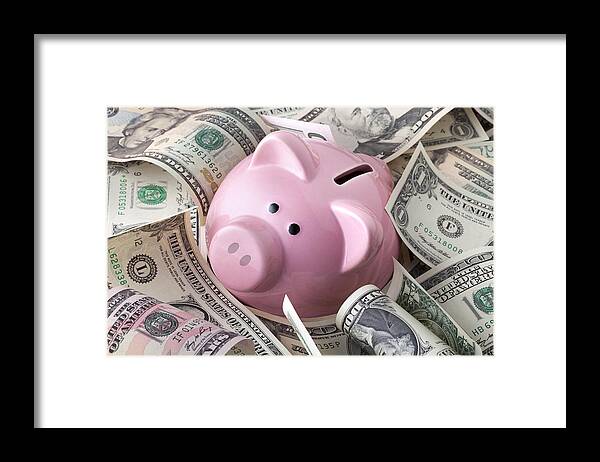 Corporate Business Framed Print featuring the photograph Piggy bank with dollars banknotes by Malerapaso