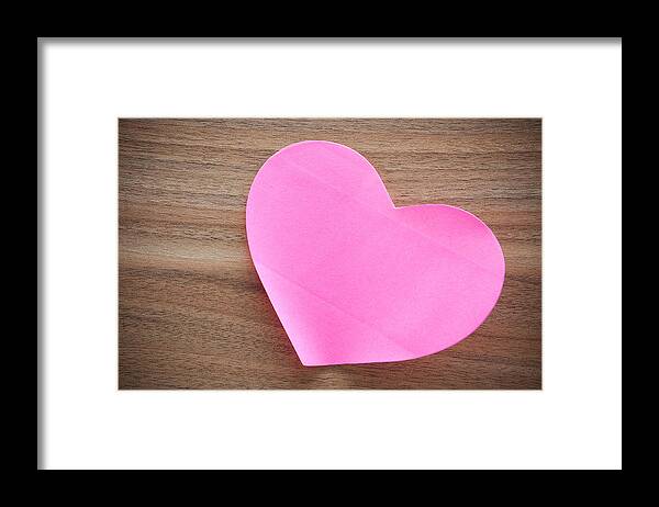 Hardwood Tree Framed Print featuring the photograph Pink paper heart shape on wood background by Hudiemm