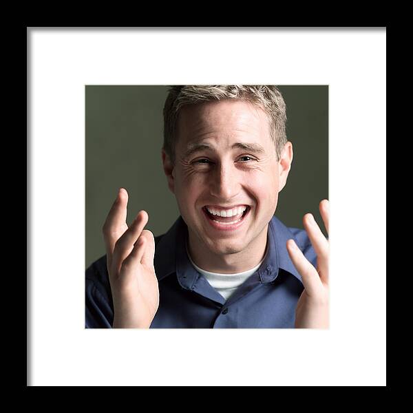 Confusion Framed Print featuring the photograph Portrait Of A Young Caucasian Man In A Blue Shirt As He Gestures With His Hands And Laughs by Photodisc