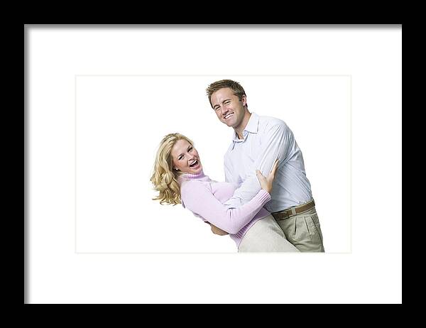 Young Men Framed Print featuring the photograph Portrait of a young couple holding each other by Photodisc