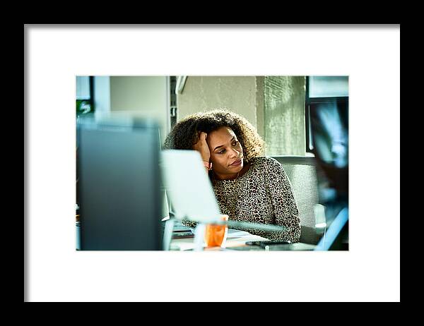 Casual Clothing Framed Print featuring the photograph Portrait of mixed race woman looking bored at desk by 10'000 Hours