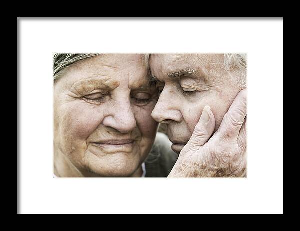 Heterosexual Couple Framed Print featuring the photograph Portrait of senior couple head to head with closed eyes by Westend61