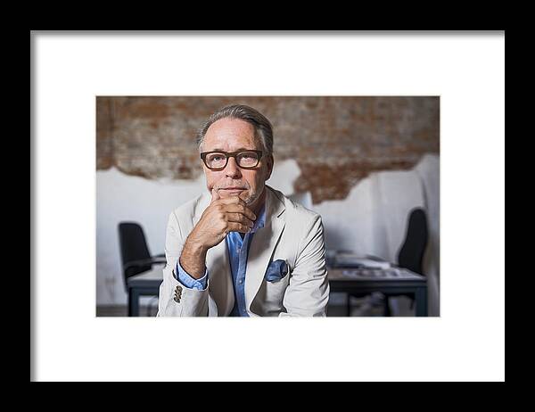 Corporate Business Framed Print featuring the photograph Portrait of serious businessman in creative office by Portra Images