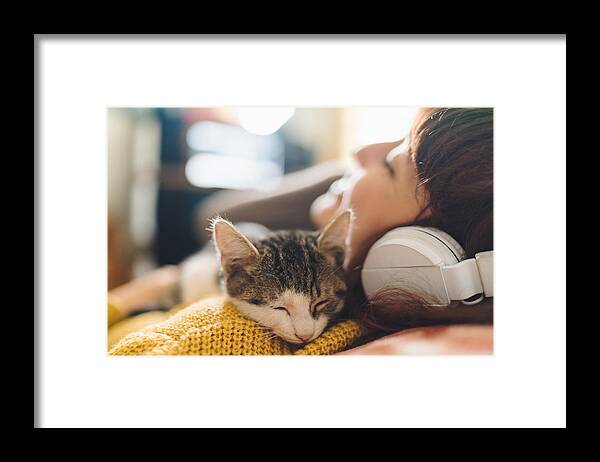 Pets Framed Print featuring the photograph Relaxed girl with cat listening to music by Martin-dm
