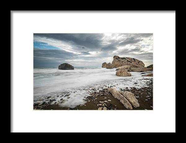 Seascape Framed Print featuring the photograph Seascape with windy waves splashing at the rocky coastal area. by Michalakis Ppalis