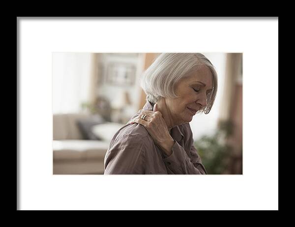 Problems Framed Print featuring the photograph Senior Caucasian woman rubbing her shoulder by Jose Luis Pelaez Inc