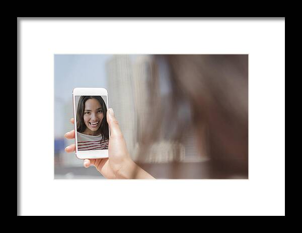 Voip Framed Print featuring the photograph Smiling Hispanic woman posing for cell phone selfie by JGI/Jamie Grill