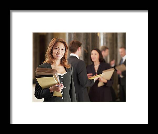 Corporate Business Framed Print featuring the photograph Smiling lawyer holding files in corridor by Chris Ryan