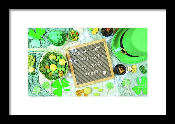 St Patrick Framed Print featuring the photograph St Patrick's Day flatlay with leprechaun hat, chocolate coins, and letter board. by Milleflore Images
