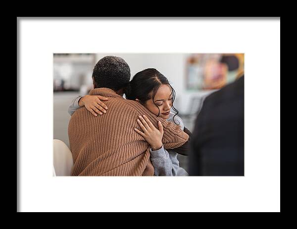 Problems Framed Print featuring the photograph Supportive women hug while attending a group therapy session by FatCamera