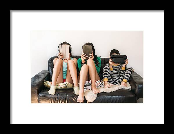Internet Framed Print featuring the photograph Three Kids With Electronic Devices On A Sofa by Os Tartarouchos