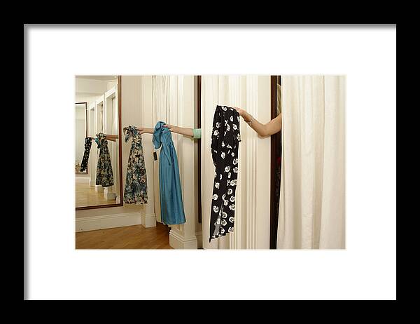 Human Arm Framed Print featuring the photograph Three women behind curtains in changing room, holding out dresses by David Woolley