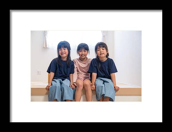 Sibling Framed Print featuring the photograph Twin girls sitting together with older sister by Trevor Williams