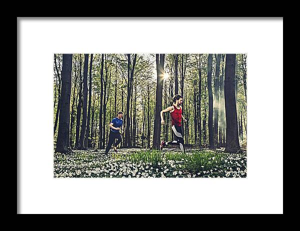 People Framed Print featuring the photograph Two male adults running in the forest in the springtime. by David Trood