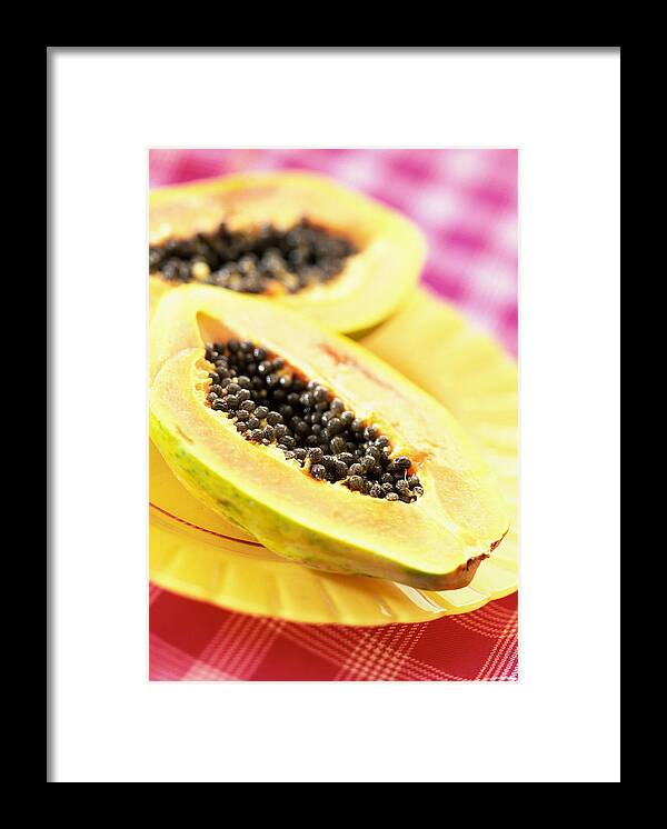 Yellow Framed Print featuring the photograph Two papaya halves on yellow plate, close-up by Jean-Blaise Hall