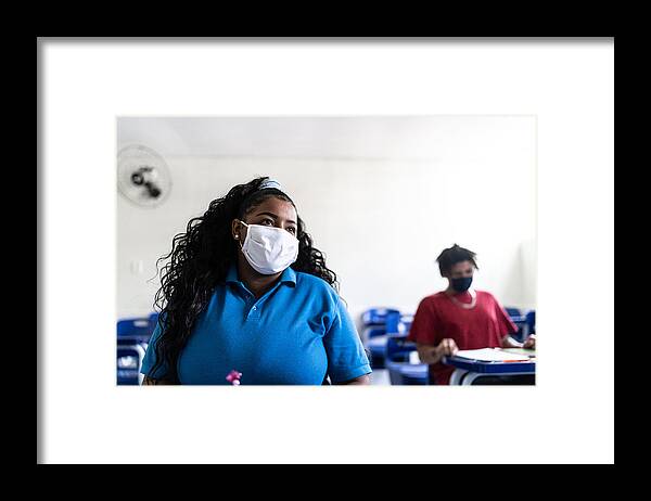 Protective Face Mask Framed Print featuring the photograph University / high school student wearing face mask while studying in the classroom by FG Trade