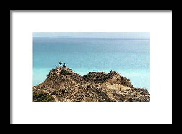 Sea Framed Print featuring the photograph Standing at the edge of a cliff enjoying sea. People hiking outdoors by Michalakis Ppalis