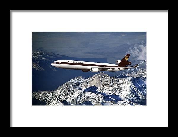 Ups. United Parcel Service Framed Print featuring the mixed media UPS MD-11F Over Snowcapped Mountains by Erik Simonsen