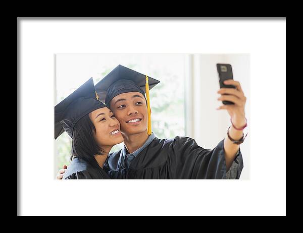 Young Men Framed Print featuring the photograph USA, New Jersey, Jersey City, Portrait of young woman and young man wearing graduation gown by Daniel Grill
