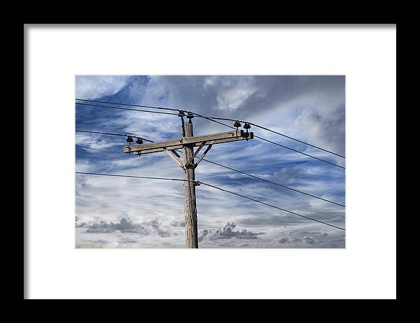 Power Framed Print featuring the photograph Utility Pole against a Cloudy Blue Sky by Randall Nyhof