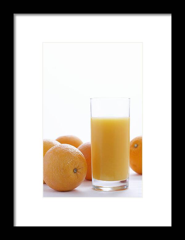 White Background Framed Print featuring the photograph Whole oranges by orange juice in glass, close-up by Martin Poole