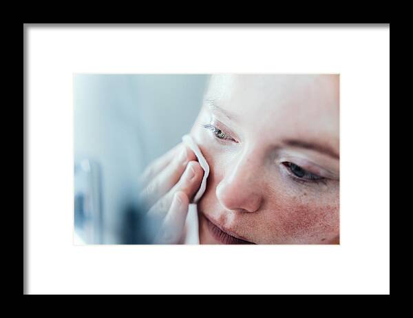 Spa Framed Print featuring the photograph Woman cleaning her face. by Guido Mieth