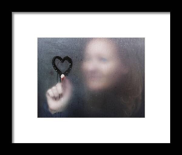 Copenhagen Framed Print featuring the photograph Woman drawing a heart on window on a rainy day. by David Trood