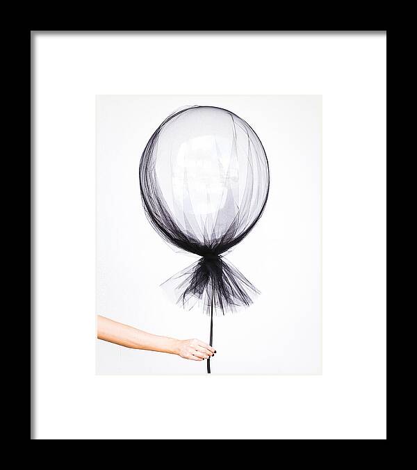 Fragility Framed Print featuring the photograph Woman hand holding balloon by David Cruz / FOAP