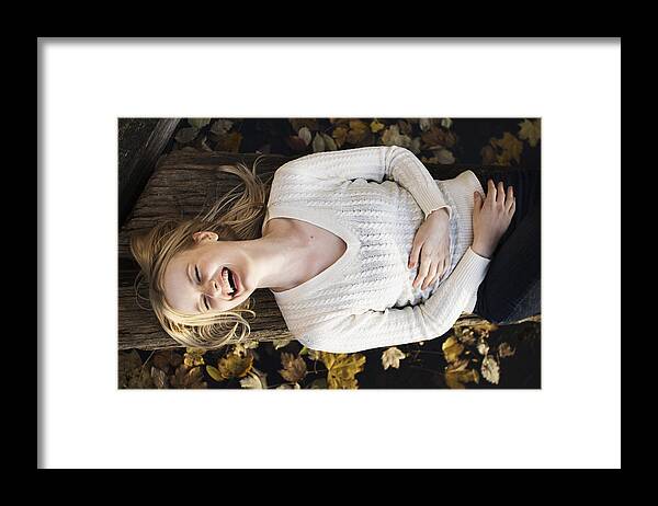 North Rhine Westphalia Framed Print featuring the photograph Woman laying on log in autumn leaves by Cultura RM Exclusive/Attia-Fotografie